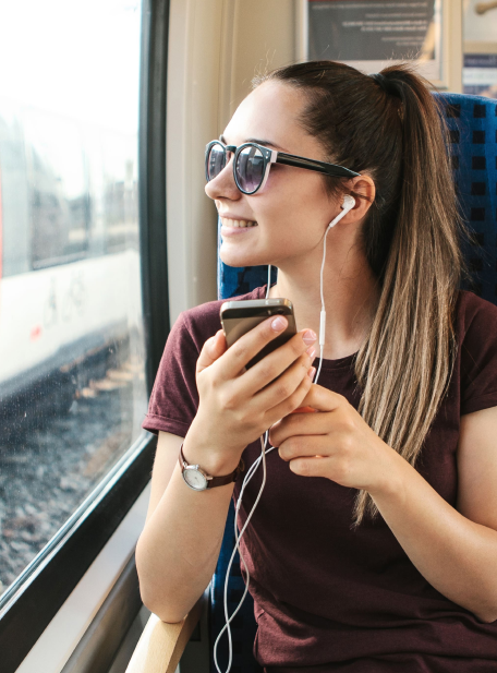 girl listening to headphones on train