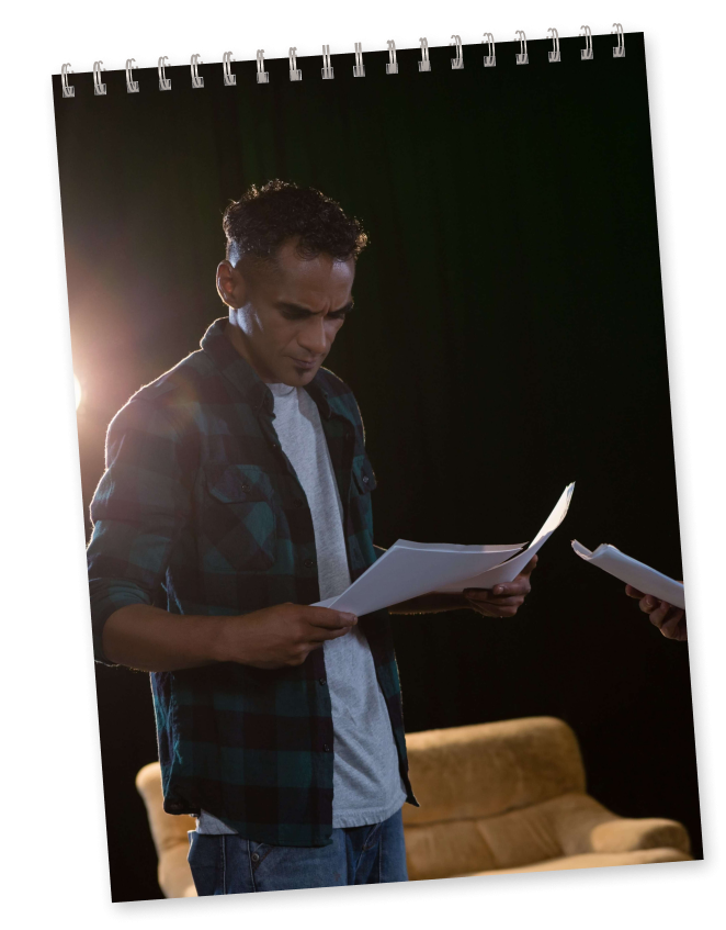 man reading a script on stage